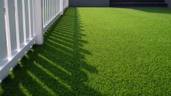 Green,Artificial,Turf,And,White,Wooden,Picket,In,Front,Yard